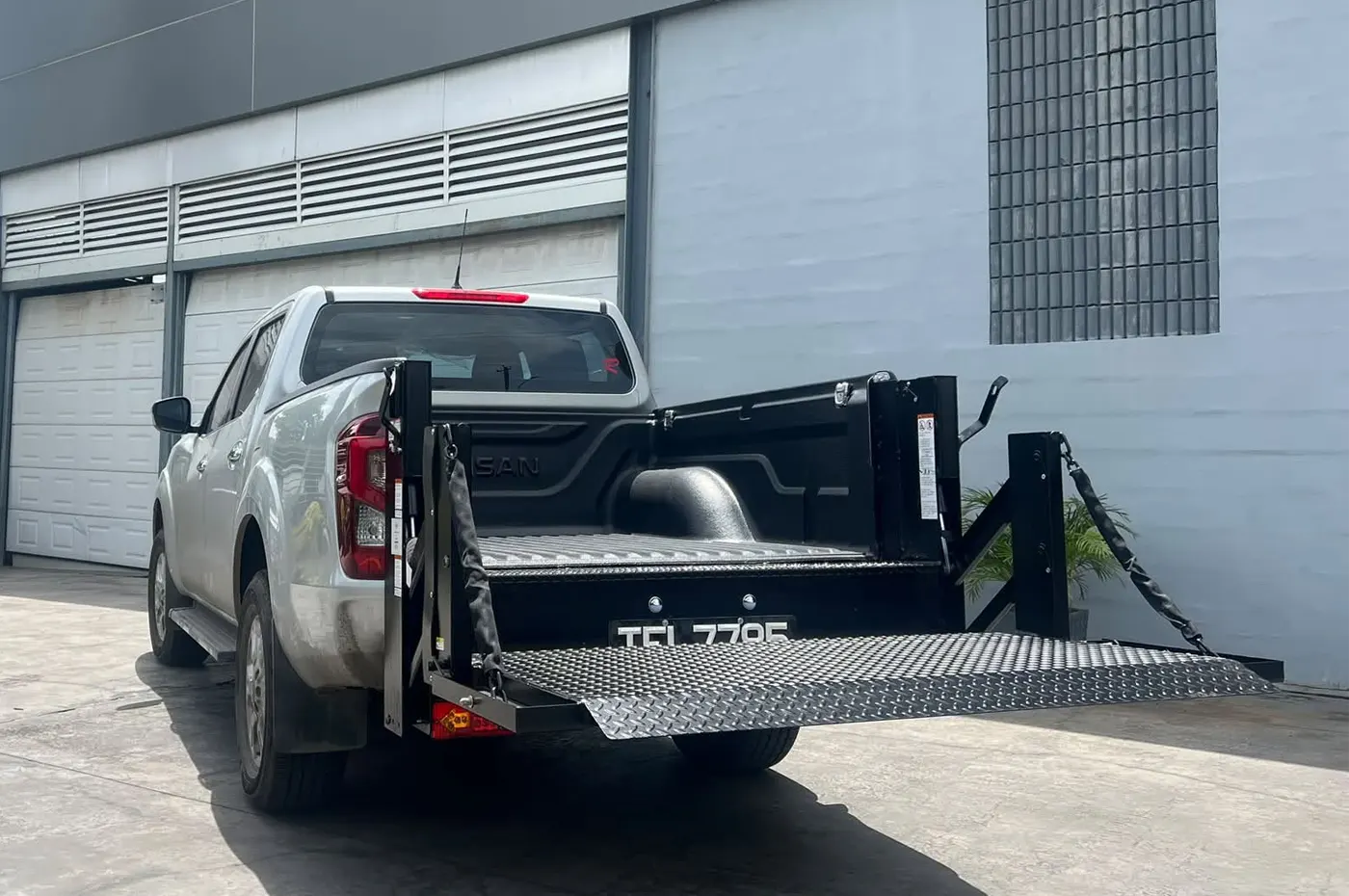 A Tommy Gate hydraulic liftgate platform lowered at the rear of an SMI-built body